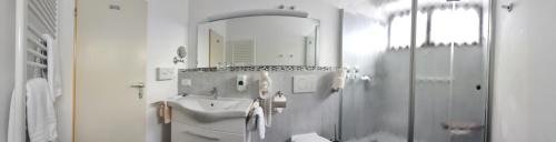 巴特皮尔蒙特巴德皮门特霍夫酒店的白色的浴室设有水槽和镜子