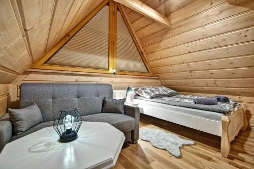 扎科帕内Domek drewniany luxury cottage Dabrowa的客房设有床、沙发和桌子。