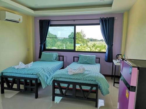Ban Nong Chum SaengBN Resort的一间卧室设有两张单人床和一个窗户。