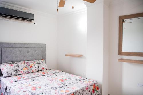 RodaderoRodadero Apartment的一间卧室配有一张带花卉床罩的床