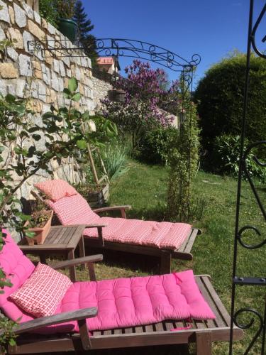 圣马丹韦叙比耶Rez de jardin de chalet bois , calme et verdure !的院子里一组带粉红色垫子的长椅