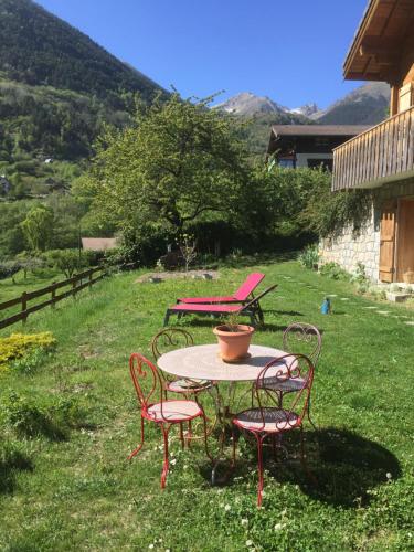 圣马丹韦叙比耶Rez de jardin de chalet bois , calme et verdure !的一张桌子,上面有四把椅子和一壶