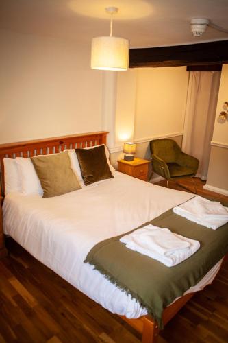 查格福德The Chagford Inn的一间卧室配有一张大床和一把椅子