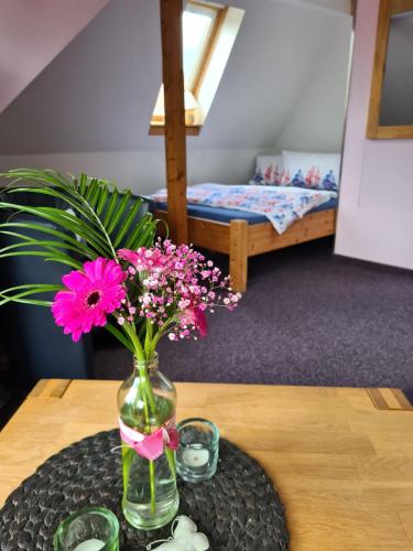 苏尔Apartment Schneestern的花瓶,花朵粉红色,坐在桌子上