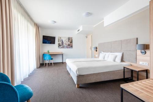 奥普尔Hotel Opole Centrum的配有一张床和一张书桌的酒店客房