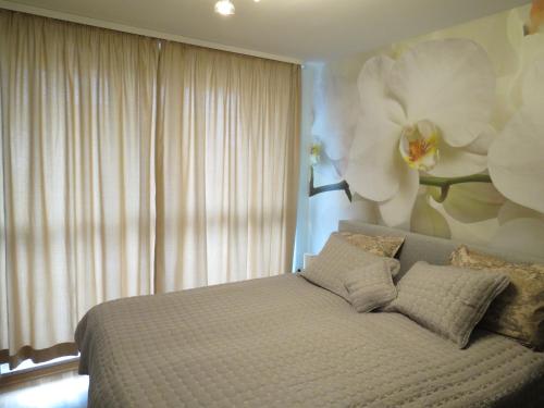 索非亚Апартхотел Б501.的卧室配有一张挂着鲜花的床