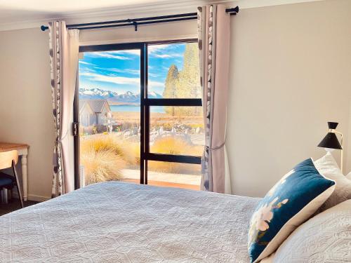 特卡波湖Alice Garden的一间卧室设有一张床和一个大窗户