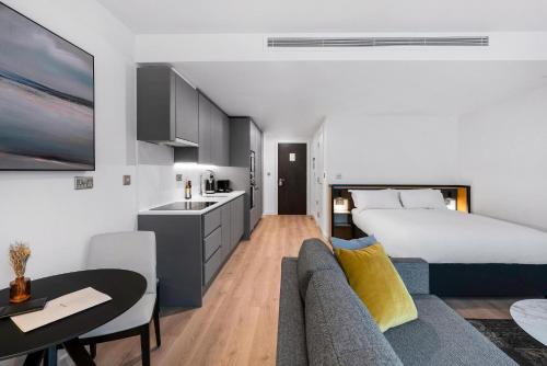 曼彻斯特CitySuites 2 Aparthotel的酒店客房配有床、沙发和桌子。