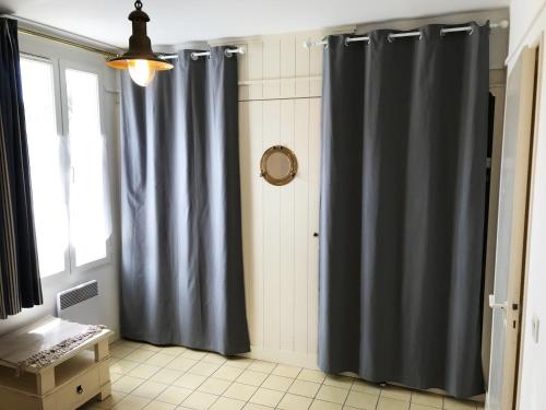 拉弗洛特LA JOLIE BRISE APPARTEMENT DANS RÉSIDENCE AVEC PISCINE的浴室设有蓝色的浴帘和窗户