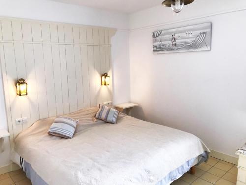 拉弗洛特LA JOLIE BRISE APPARTEMENT DANS RÉSIDENCE AVEC PISCINE的一间卧室配有一张带两个枕头的床