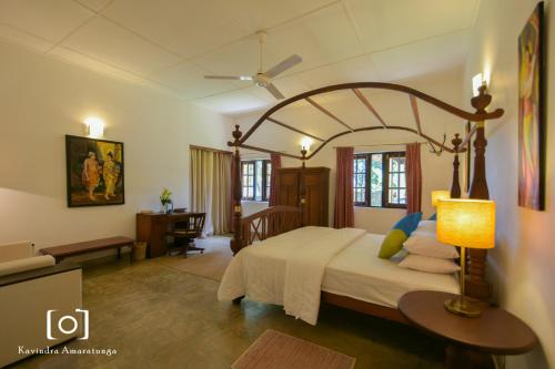 ArawwawalaCaptain's Bungalow, Kandy的一间卧室配有一张大床和一张书桌
