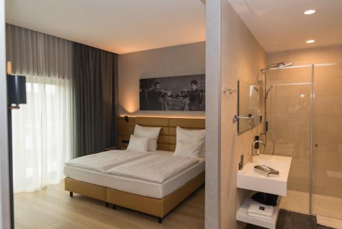 地拉那mk hotel tirana的一间带一张床和淋浴的小卧室