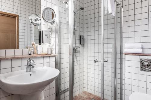 马尔默The More Hotel Mazetti的白色的浴室设有水槽和淋浴。