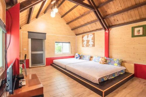 冬山乡田心民宿的一间设有床铺的卧室,位于一个红色墙壁的房间