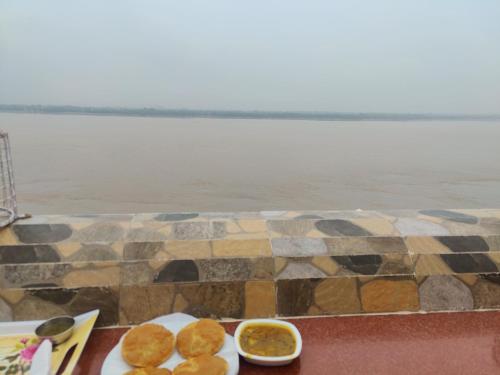 瓦拉纳西湿婆恒河景观旅馆的水边有两盘食物的桌子