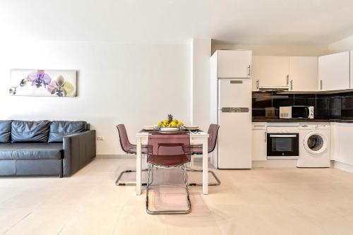 洛斯克里斯蒂亚诺斯Hortensia Suites Apartments ,Los Cristianos的厨房以及带桌子和沙发的客厅。