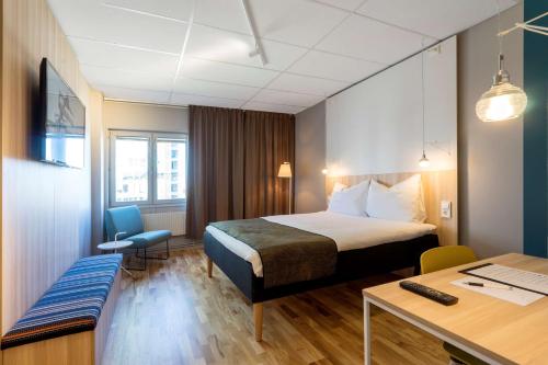 斯德哥尔摩希斯塔斯堪的克酒店的配有一张床和一张书桌的酒店客房