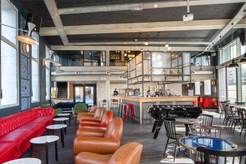波尔多Eklo Bordeaux Centre Bastide的一间设有红色沙发和桌子的餐厅和一间酒吧