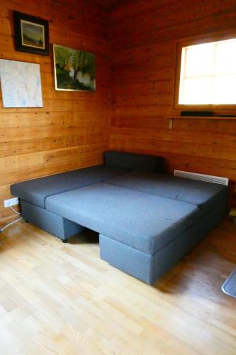 KotilaMetsorinne 3A sarvipöllö的一张蓝色的大床,位于带木墙的房间