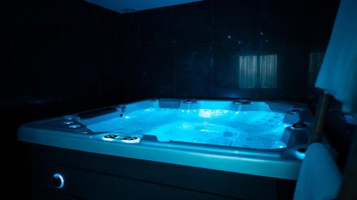 乐罗夫Love night Marseille jacuzzi的深色客房内的蓝色浴缸