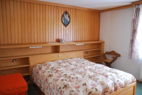 萨帕达Appartamento Anna & Gino的一间卧室设有一张床和木墙