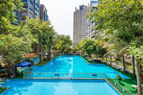 景洪市豆豆湄澜风情客栈的棕榈树城市的大型游泳池