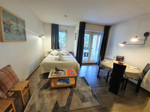夏蒙尼-勃朗峰La Riviere Vue Mont Blanc的配有床、桌子和沙发的房间