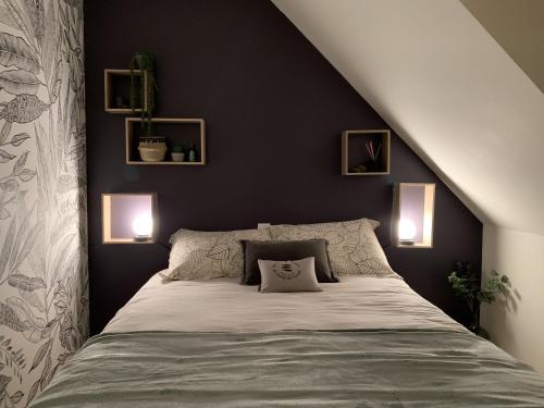 桑泰克L'escale 551, gîte Santec à 250m de la plage的卧室配有一张带两盏灯的墙壁床。