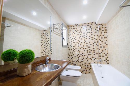 塔拉戈纳Atico junto a la Catedral的浴室配有盥洗盆、卫生间和浴缸。