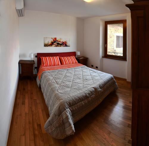 蒙特卡蒂尼泰尔梅Appartamento Clary的一间卧室配有一张带红色枕头的大床