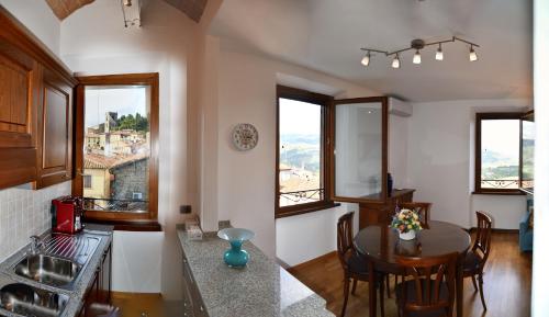 蒙特卡蒂尼泰尔梅Appartamento Clary的厨房以及带桌子和一些窗户的用餐室。
