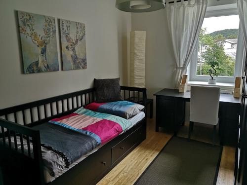 新特尔布鲁Studios Am Wienerwald的一间卧室配有一张床、一张书桌和一个窗户。