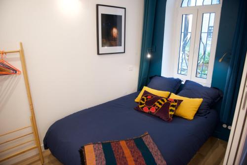 巴黎CHARMING Parisian Apartment WITH AIR CONDITIONING - CLIMATISATION & 2 BEDROOMS - Batignolles PARIS的一间卧室配有蓝色的床和枕头