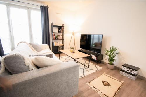 普瓦西Joli studio tout confort à 2 pas de la gare Poissy的带沙发和电视的客厅