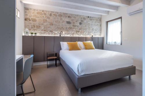 Roveredo in PianoPortone180 Guest House的一间卧室设有一张床和砖墙