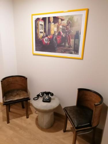 奥里奥阿塞里奥Ferrari Formula 1的一间设有两把椅子和一张桌子的房间,一张图片