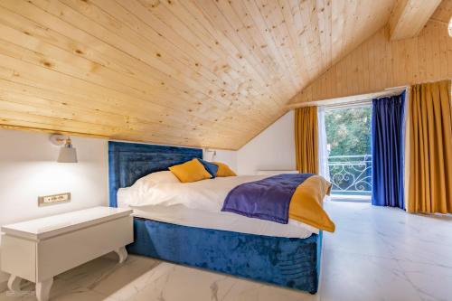 奥赫里德Risteski Apartments - St. Naum的一间卧室设有一张床和木制天花板