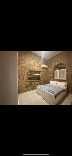 卢克索Nile palace villa的一间卧室设有一张带石墙的大床