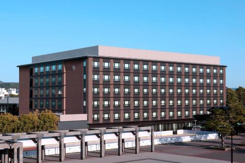 京都The Royal Park Hotel Kyoto Umekoji的一座大型的棕色建筑,有很多窗户