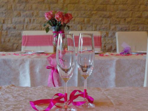 杜什尼基-兹德鲁伊Ośrodek Pegaz的桌上放两杯葡萄酒,放着玫瑰花瓶