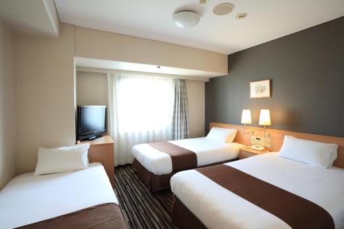 德岛德岛微笑酒店的酒店客房设有两张床和电视。