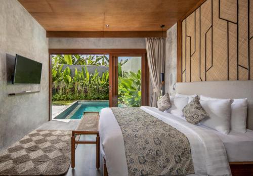 吉安雅Agrapana Beach Villa的一间卧室设有一张床、一台电视和一个游泳池