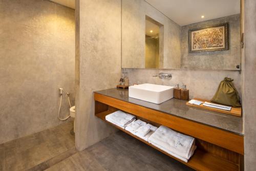 吉安雅Agrapana Beach Villa的浴室配有盥洗盆和带毛巾的台面。