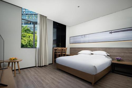 深圳Unijoy Cityinn OCT Loft Shenzhen有集城市客栈创意园店的一间卧室设有一张床和一个大窗户