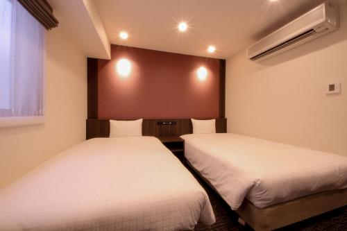 名古屋Compass Hotel Nagoya的小型客房 - 带2张床和窗户