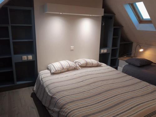 朗波普卢阿尔泽La Lanterne du Bout du Monde的一间卧室配有一张带两个枕头的床