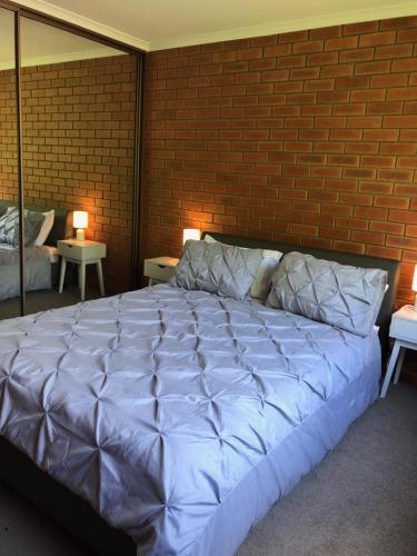 金斯顿Kingston Pines的砖墙房间内一张大白色的床