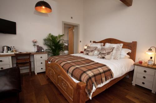 SnaithThe Pig Inn的一间卧室配有一张带枕头的大型木制床。