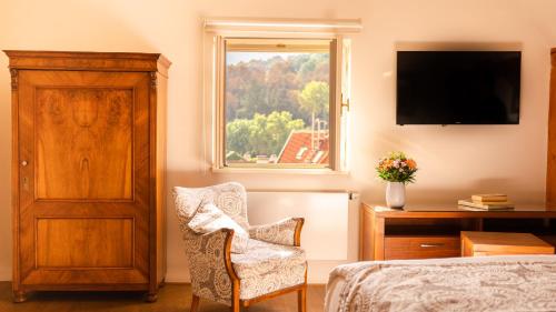 布拉格Hotel Golden Key Prague Castle的卧室配有床、椅子和窗户。