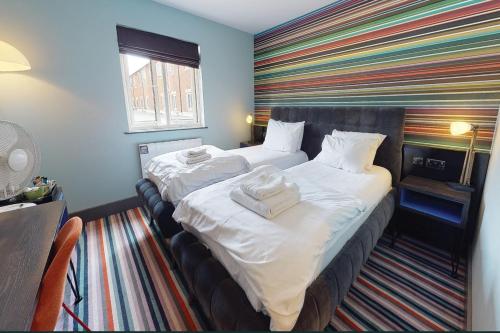 考文垂考文垂乡村酒店的酒店客房设有两张床和条纹墙